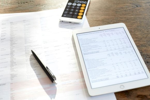 Calcolo dell'ammortamento di un'ipoteca con l'aiuto di documenti fiscali e di una calcolatrice.