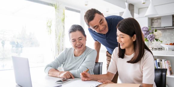 Happy Asian family making future plans over the table