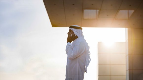 رجل أعمال عربي يتحدث على الهاتف الجوال