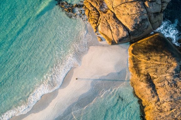 Man walking along sidebar beach, Australia