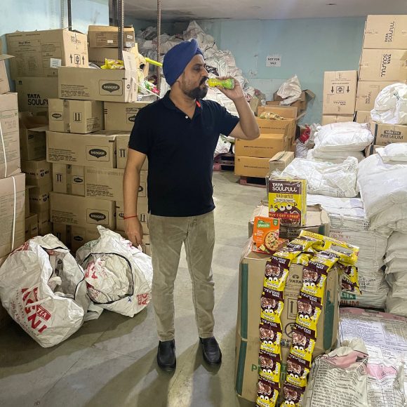 Analyst sampling a drink in a warehouse.