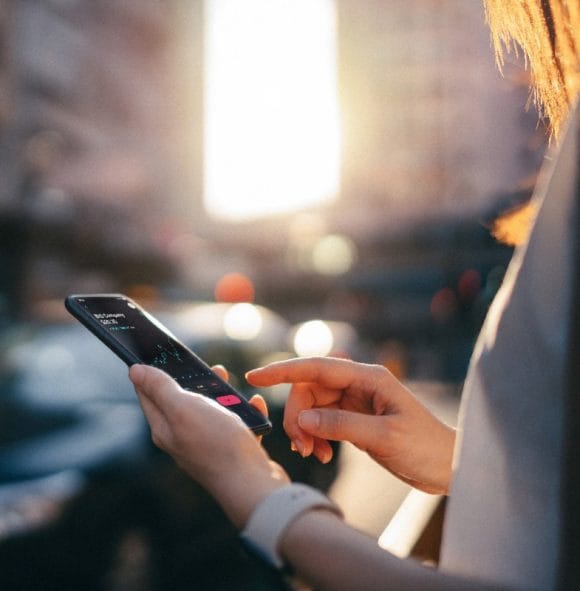 A person looking at a mobile phone while typing a message.