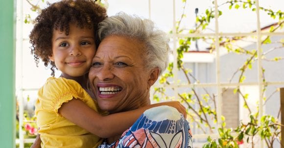 Grandmother and granddaughter hugging.