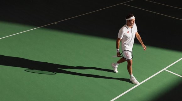 Roger Federer standing on green court.