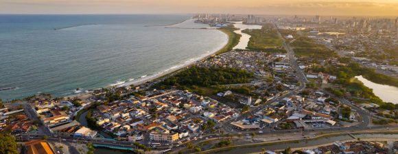 Vista aérea de uma cidade litorânea com praia no Brasil