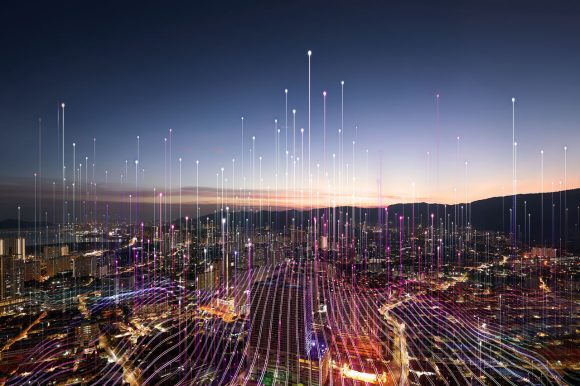 A decorative picture of a futuristic city skyline with beams of light rising into the sky