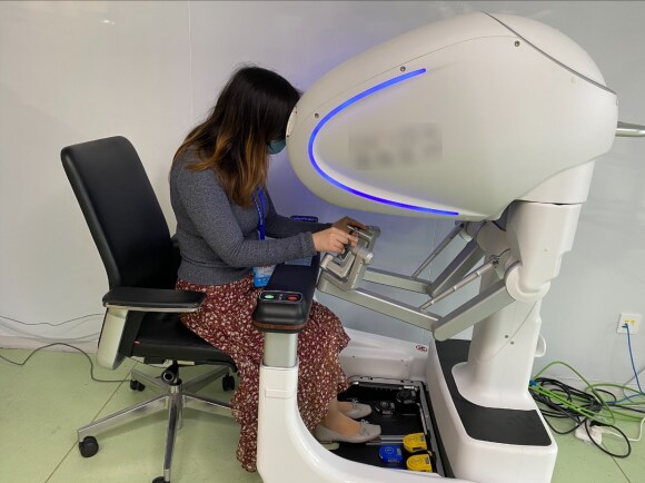 image 1 : Healthcare analyst Cui Cui is trying out a Chinese-made surgical robot during a company visit.
