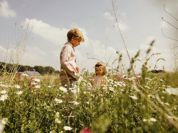 Zwei Kinder spielen auf einer Wiese.