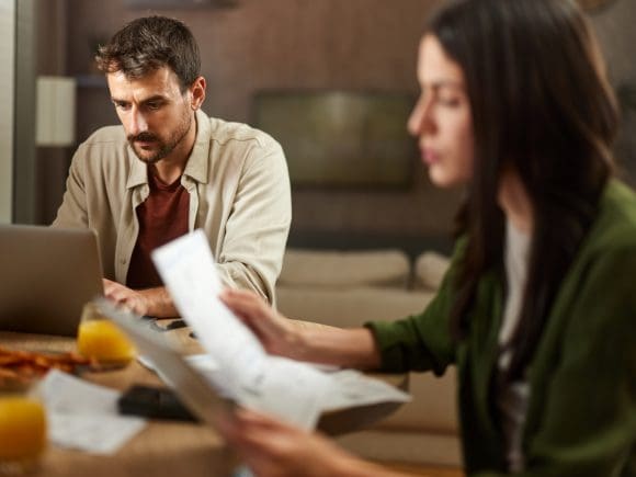 Back view of a woman in a light-colored trouser suit climbing a flight of stairs.