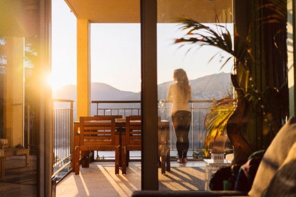 Woman standing on balcony of home