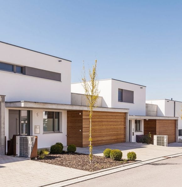 Moderne neu gebaute Einfamilienhäuser in einer Wohnsiedlung mit klarer Architektur und angelegten Aussenbereichen.