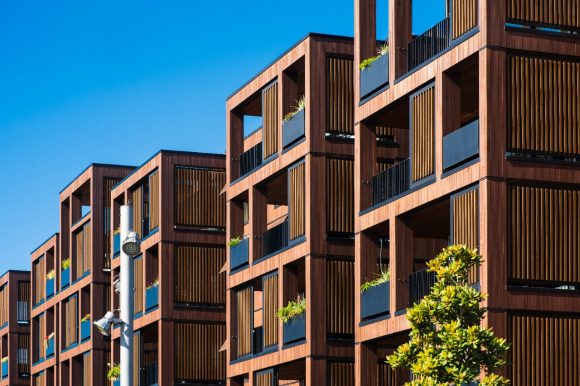 Eine Hand streicht einen Farbpinsel an einer Wand.