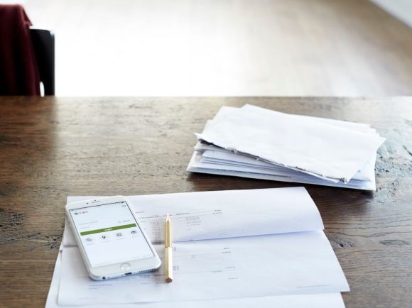 A smartphone with the UBS app open lies on top of an opened letter.
