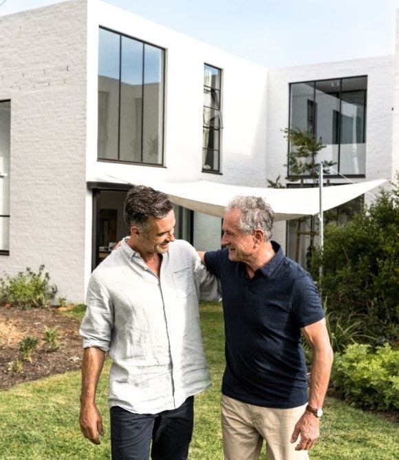 Vater und Sohn spazieren im Garten und unterhalten sich.