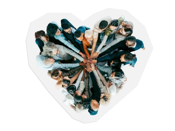 A team seen from above places their hands on top of each other.