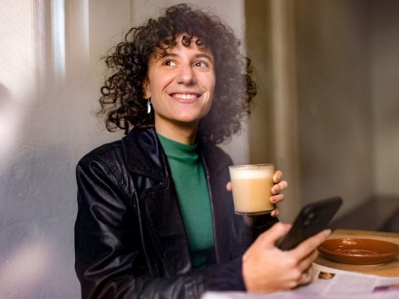 A laughing young lady having glass in her hand