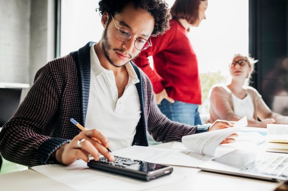 A young man counting tax profits