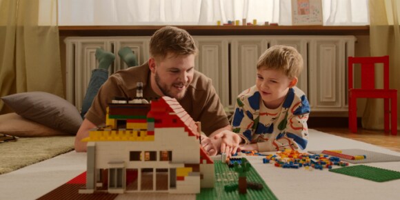 Vater und Sohn spielen mit Bausteinen auf dem Boden