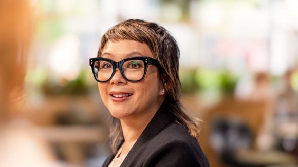 A woman wearing glasses looking directly into the camera.