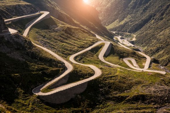 Long and winding road through steep green hills