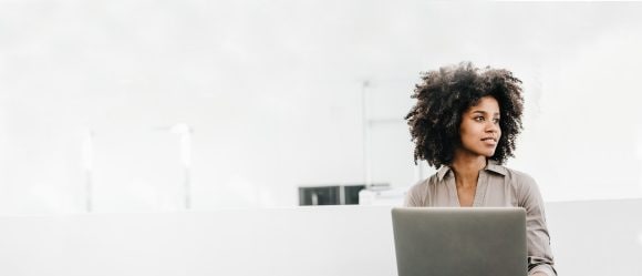 Femmes aux cheveux bouclés travaillant sur un ordinateur portable