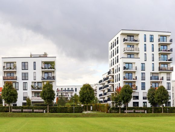 Immeubles avec espaces verts au premier plan: image symbolique pour l’évaluation des immeubles de rendement
