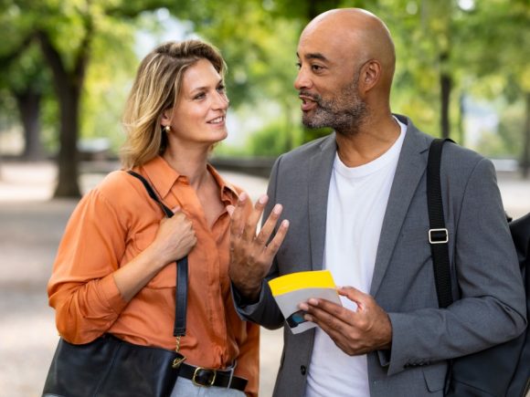 Un couple en tenue de bureau passe un bon moment dans un parc.