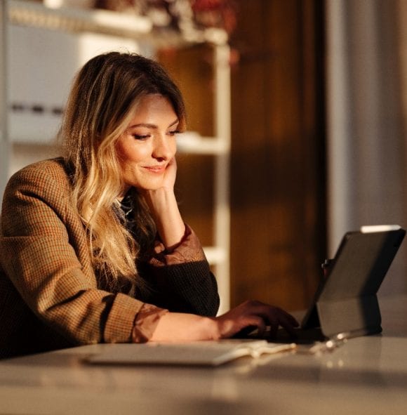 Une femme est assise à un bureau avec un ordinateur portable.