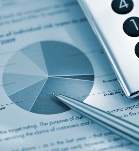 Financial report in cool blue-gray colors showing a pie chart, with a silver pen lying across