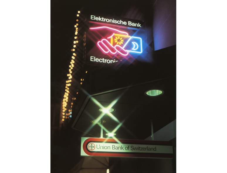The illuminated neon sign of the Electronic Bank