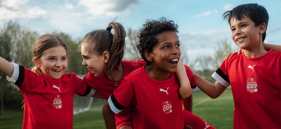 Das Bild zeigt Jubelnde Kinder auf dem Fussballplatz.
