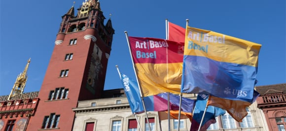 L’image montre des drapeaux portant la marque Art Basel à Bâle.