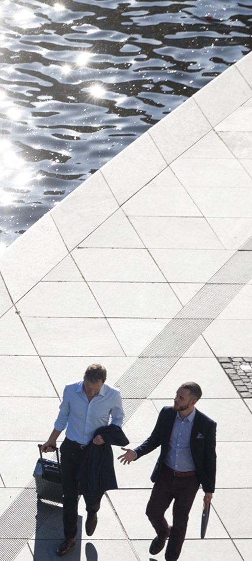 A client and UBS Advisor walking and having a conversation next to the water.