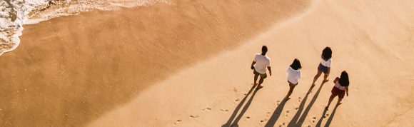 Una familia caminando por la playa.