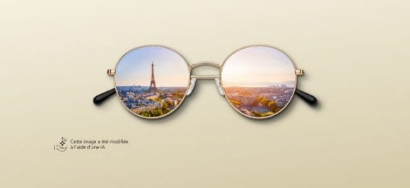 Sur l’image, on voit une paire de lunettes de soleil dans les verres desquelles se reflète une ville.