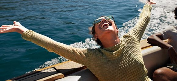 L’image montre une femme heureuse sur un bateau.