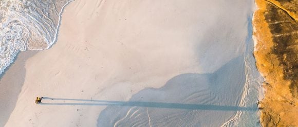 Aerial view of a person riding horseback across a beach