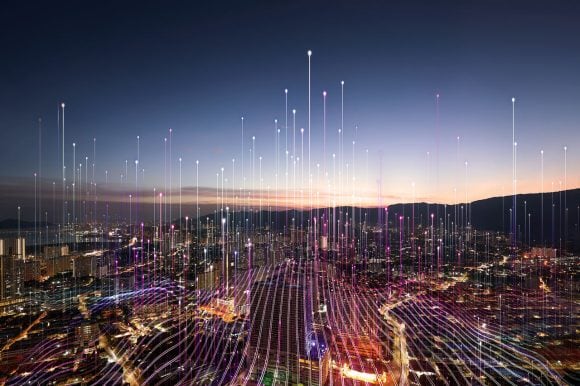 A decorative picture of a futuristic city skyline with beams of light rising into the sky