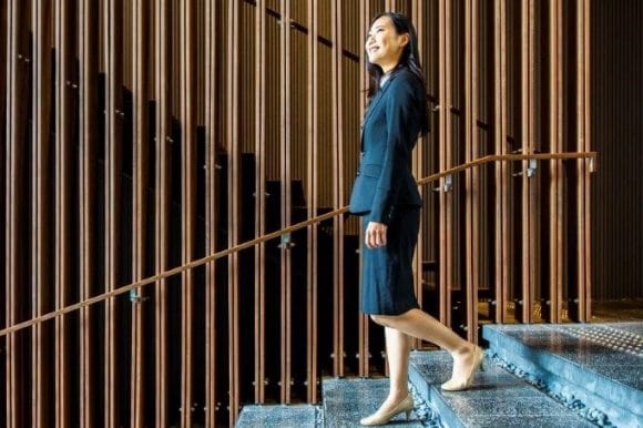 A smiling lady walking down the stairs