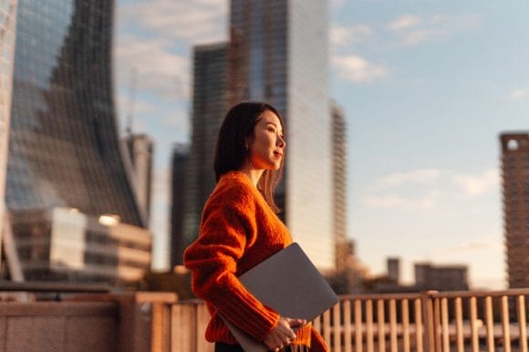 Businesswoman with laptop against London financial district