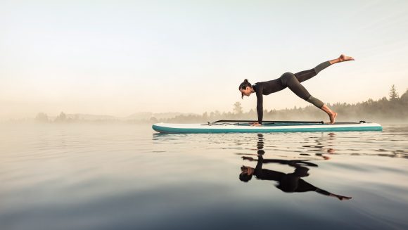 Woman doing yoga on stand-up paddle board