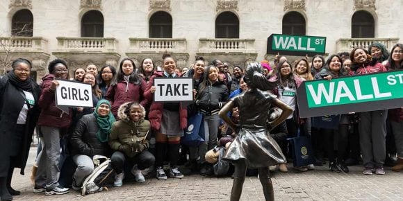 Eine Gruppe von Mädchen mit Schildern: Girls take Wall Street