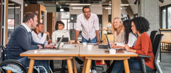 Vier Mitarbeiter arbeiten gemeinsam an einem Tisch