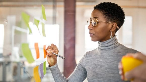 Frau schreibt auf Haftnotizen