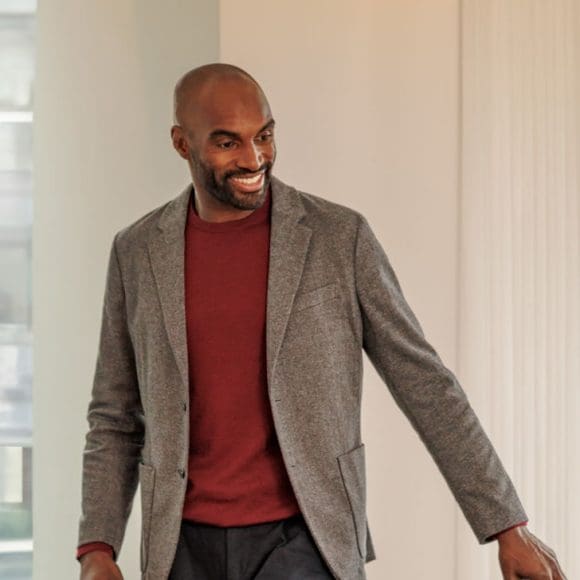 Man sitting down next to a colleauge at a meeting table