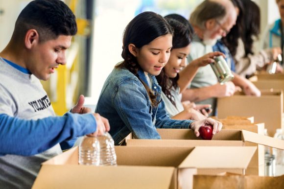 Volunteers sorting food donations into boxes