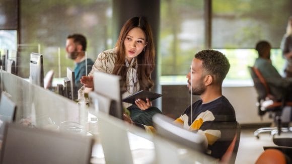 Two colleagues discussing in front of computer