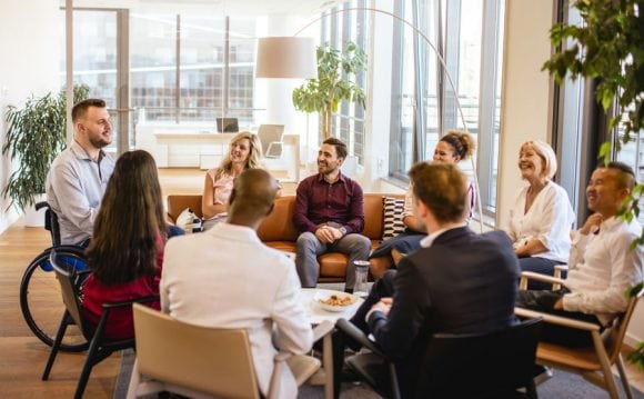 Group of people discussing in office lounge area