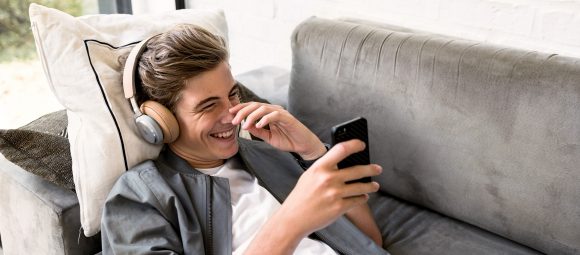 Teenage son laying on the sofa with headphones