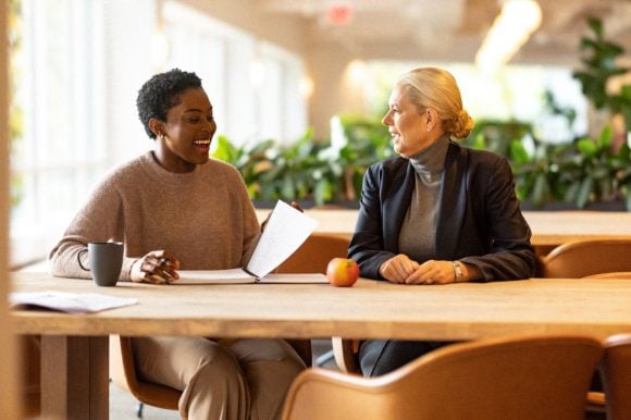 Two women working in office space